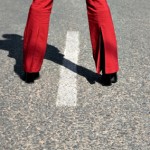 Conceptual, woman with red trousers on the highway